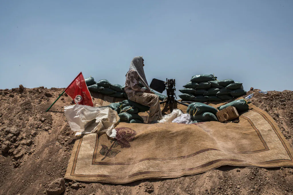 An Iraqi PMF machine-gunner on the Iraq-Syria border, June 20, 2017. (Martyn Aim/Getty Images).