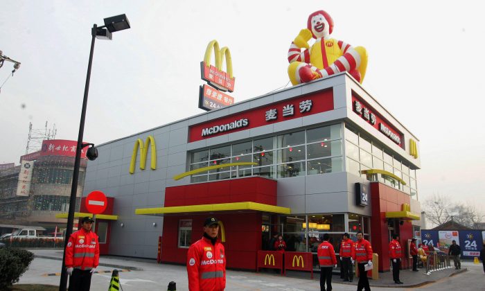 Chinese staff wait for the first customers at the opening of a McDonald's drive-thru outlet built next to a gas station in Beijing on Jan. 19, 2007. McDonald’s, after announcing that it would change its name in China, drew ridicules on Chinese social media. (STR/AFP/Getty Images)