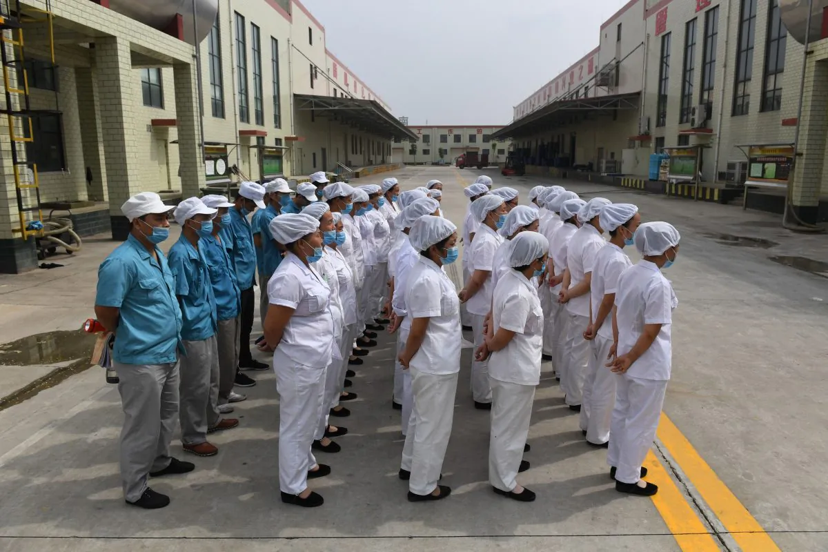 Workers lined up to sing communist ‘red’ songs at an instant noodle factory, near a village in China’s central Henan Province on Sept. 29, 2017. Recently the Chinese Communist Party has further extended its control on companies with both private and foreign-owned, with party branches. (Greg Baker/AFP/Getty Images)