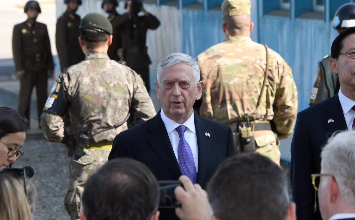 Secretary of Defence Jim Mattis (C) speaks to the media as South Korean Defence Minister Song Young-Moo (R) looks on during a visit to the Demilitarized Zone. North Korean soldiers can be seen in the background. (JUNG YEON-JE/AFP/Getty Images)
