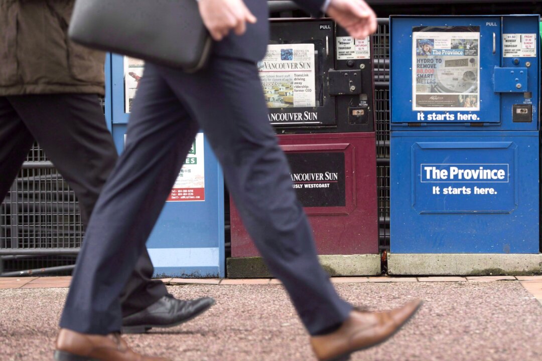Pedestrians pass newspaper boxes in downtown Vancouver. (The Canadian Press/Jonathan Hayward)