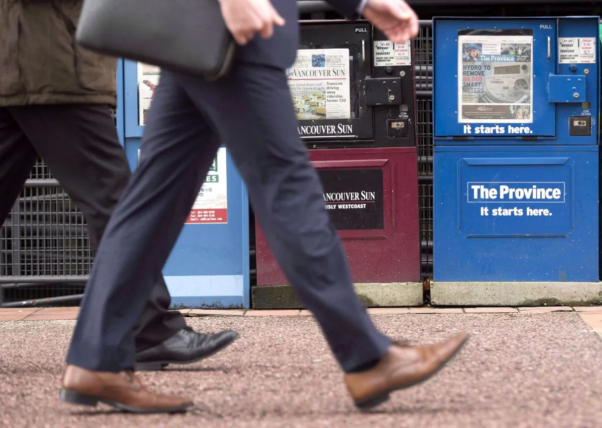 Pedestrians pass newspaper boxes in downtown Vancouver. (The Canadian Press/Jonathan Hayward)