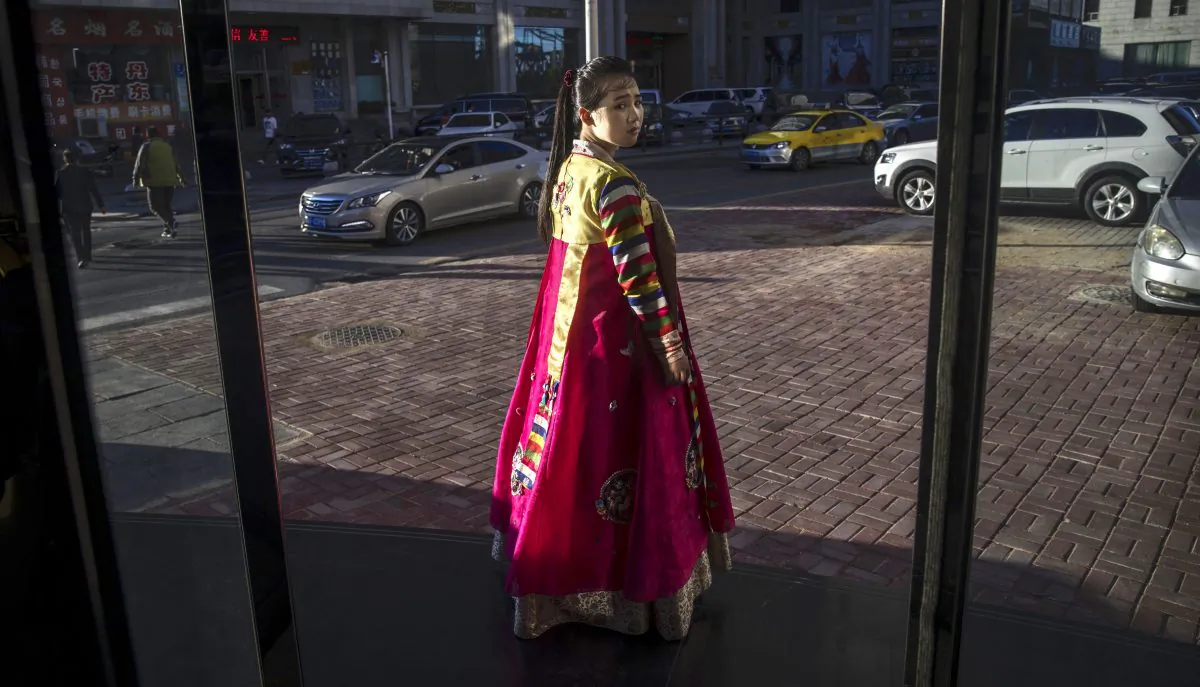 A North Korean restaurant worker tries to attract customers in the border city of Dandong, Liaoning Province, northern China across the Yalu River from the border city of Sinuiju, North Korea on May 23, 2017 in Dandong, China. Many North Korean women who flee are trafficked into forced marriages in China.  (Kevin Frayer/Getty Images)