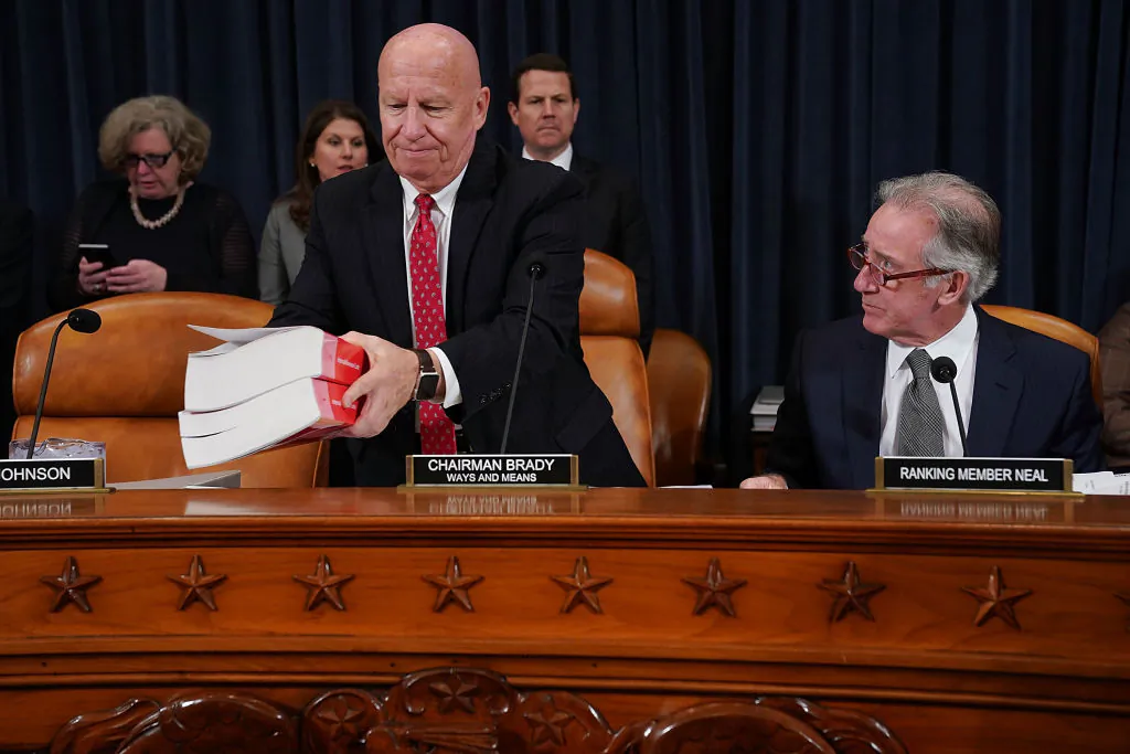 House Ways and Means Committee Chairman Kevin Brady (R-Texas) (L) sets down a copy of the current tax code as he and ranking member Rep. Richard Neal (D-Mass.) prepare for the first markup hearing of the proposed GOP tax reform legislation in the Longworth House Office Building on Capitol Hill in Washington, on Nov. 6, 2017.
(Chip Somodevilla/Getty Images)