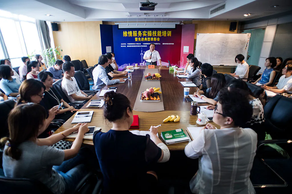 Shu Xin, the head of Weiqing, a company that offers a team of “mistress hunters,” speaks to his colleagues during a meeting in Shanghai on July 8, 2016. (Johannes Eisele/AFP/Getty Images)