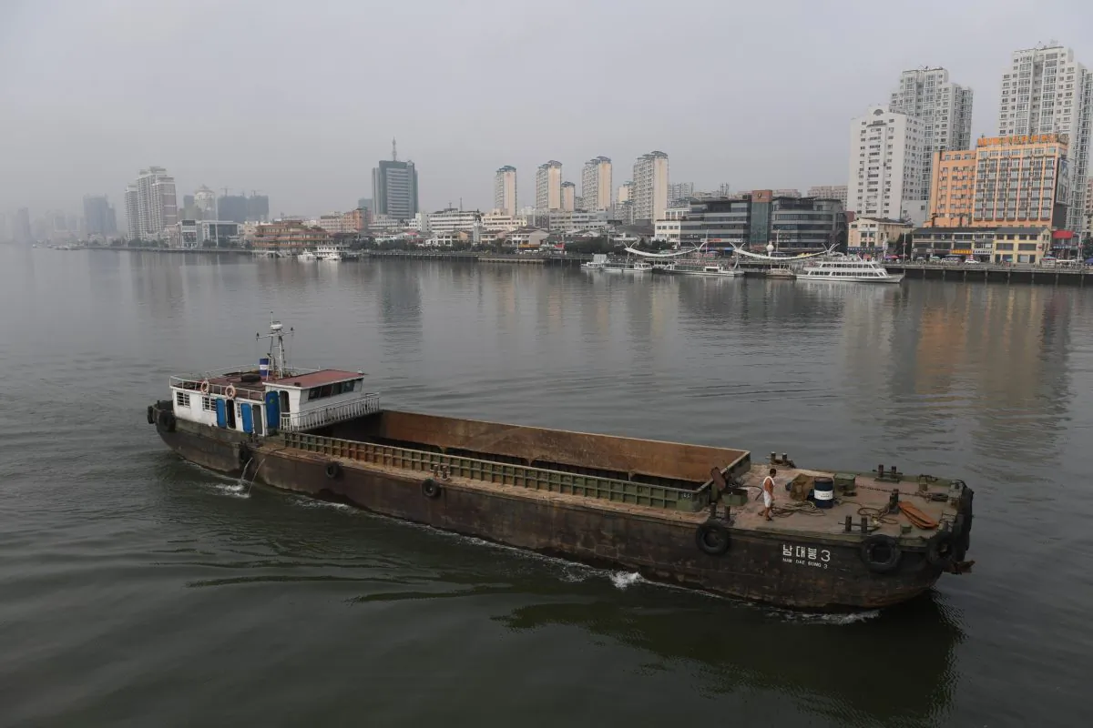 A North Korean ship passes in front of the waterfront of the Chinese border city of Dandong (at rear), in China's northeast Liaoning Province on Sept. 4, 2017. The U.S. Department of the Treasury added more than a dozen business entities to the list of companies targeted by U.S. sanctions against North Korea, including a Chinese company accused of helping the North Korean regime to develop weapons of mass destruction. (Greg Baker/AFP/Getty Images)
