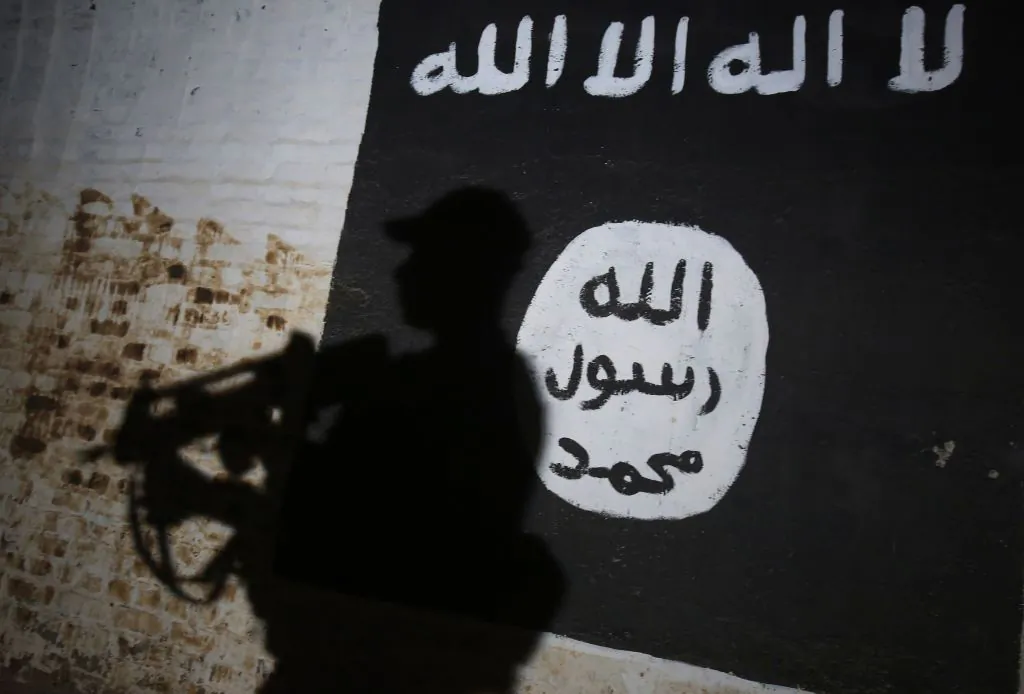A member of the Iraqi forces walks past a mural bearing the logo of the ISIS group in a tunnel that was reportedly used as a training centre by the jihadists, in the village of Albu Sayf, on the southern outskirts of Mosul, on March 1, 2017. (Ahmad Al-Rubaye/AFP/Getty Images)