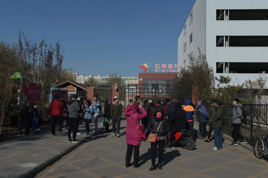 People stand in front of the main gate of the RYB Education kindergarten in Beijing on Nov. 24, 2017. Chinese police have launched an investigation into alleged child abuse at the Beijing kindergarten. (Nicolas Asfouri/AFP/Getty Images)