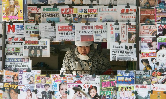 A newspaper vendor peers from her stall in Beijing, China, on Dec. 10, 2004. (Guang Niu/Getty Images)