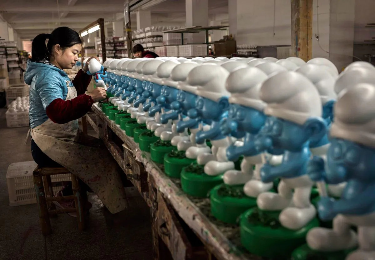 A Chinese worker paints unfinished licensed ceramic "Smurfs" at a factory in Dehua County, Fujian Province, China on December 7, 2014. (Kevin Frayer/Getty Images)
