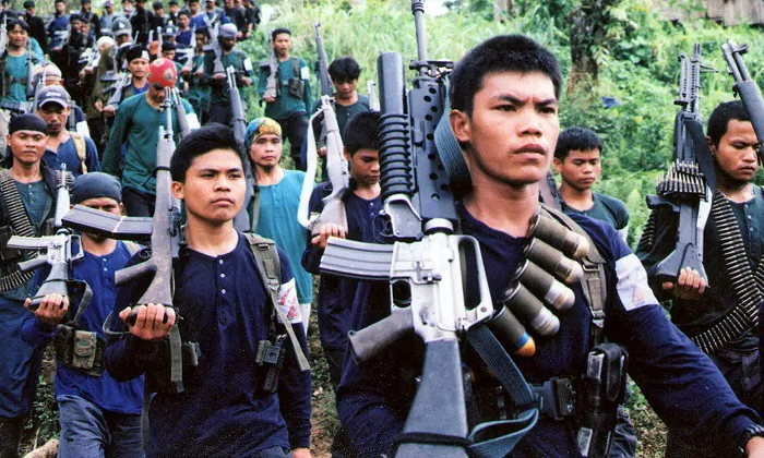 This 2004 file photo shows a communist New People's Army (NPA) guerrilla unit marching in formation during a press visit to their jungle camp in the rebel's mountain stronghold in southern Mindanao. Philippine President Rodrigo Duterte has classified the Communist Party of the Philippines and its armed wing the NPA as a terrorist organization. (AFP/AFP/Getty Images)