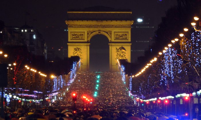 People gather on the Champs-Elysees avenue in Paris to celebrate the New Year, late on December 31, 2012. AFP PHOTO / MIGUEL MEDINA        (Photo credit should read MIGUEL MEDINA/AFP/Getty Images)
