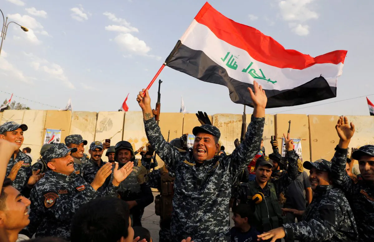 FILE PHOTO: A member of Iraqi Federal Police waves an Iraqi flag as they celebrate victory of military operations against the ISIS terrorists in West Mosul, Iraq July 2, 2017. (Reuters/Erik De Castro/File Photo)