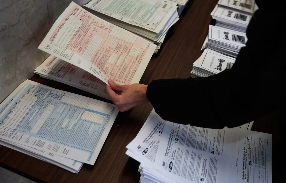 A woman picks up tax forms in the lobby of the Farley Post Office in New York City on April 15, 2008. (Chris Hondros/Getty Images)