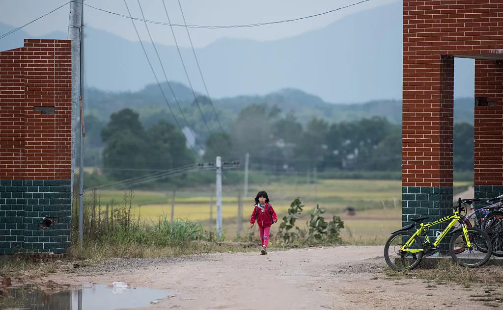 A schoolgirl walks along the street in Pingjiang County in China’s Hunan Province on Oct. 8, 2015. (Johannes Eisele/AFP/Getty Images)