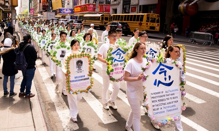 Falun Gong practitioners hold wreaths with photos of people who were killed inside China for their beliefs, at a parade along 42nd Street in New York City on May 12, 2017. (Samira Bouaou/The Epoch Times)