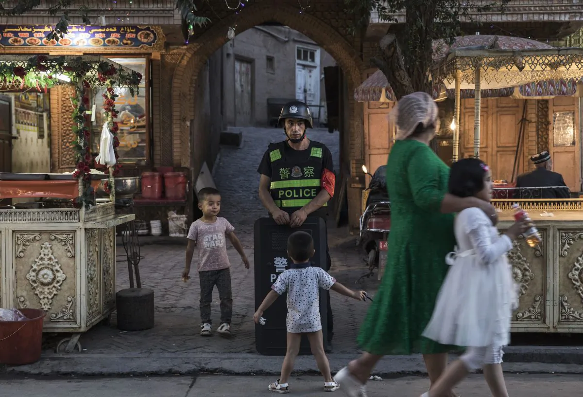 Uyghur children play while a local police officer looks on, in Kashgar, Xinjiang on June 29, 2017. Xinjiang is located in China's far northwest. (Kevin Frayer/Getty Images)