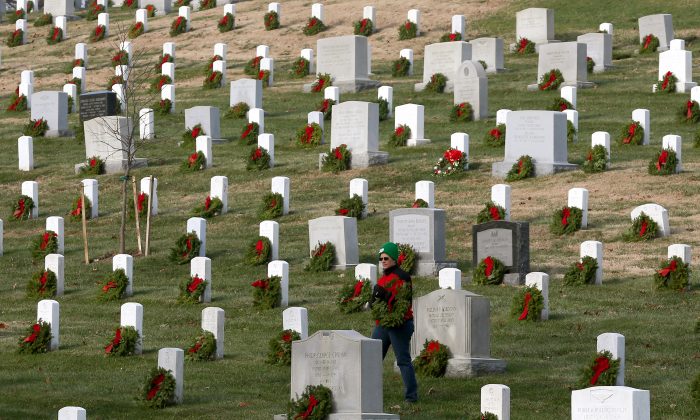 A volunteer looks for a grave to place a wreath on during the National Wreaths Across America Day at Arlington National Cemetery, in Arlington, Virginia in Dec. 13, 2014. (Mark Wilson/Getty Images)