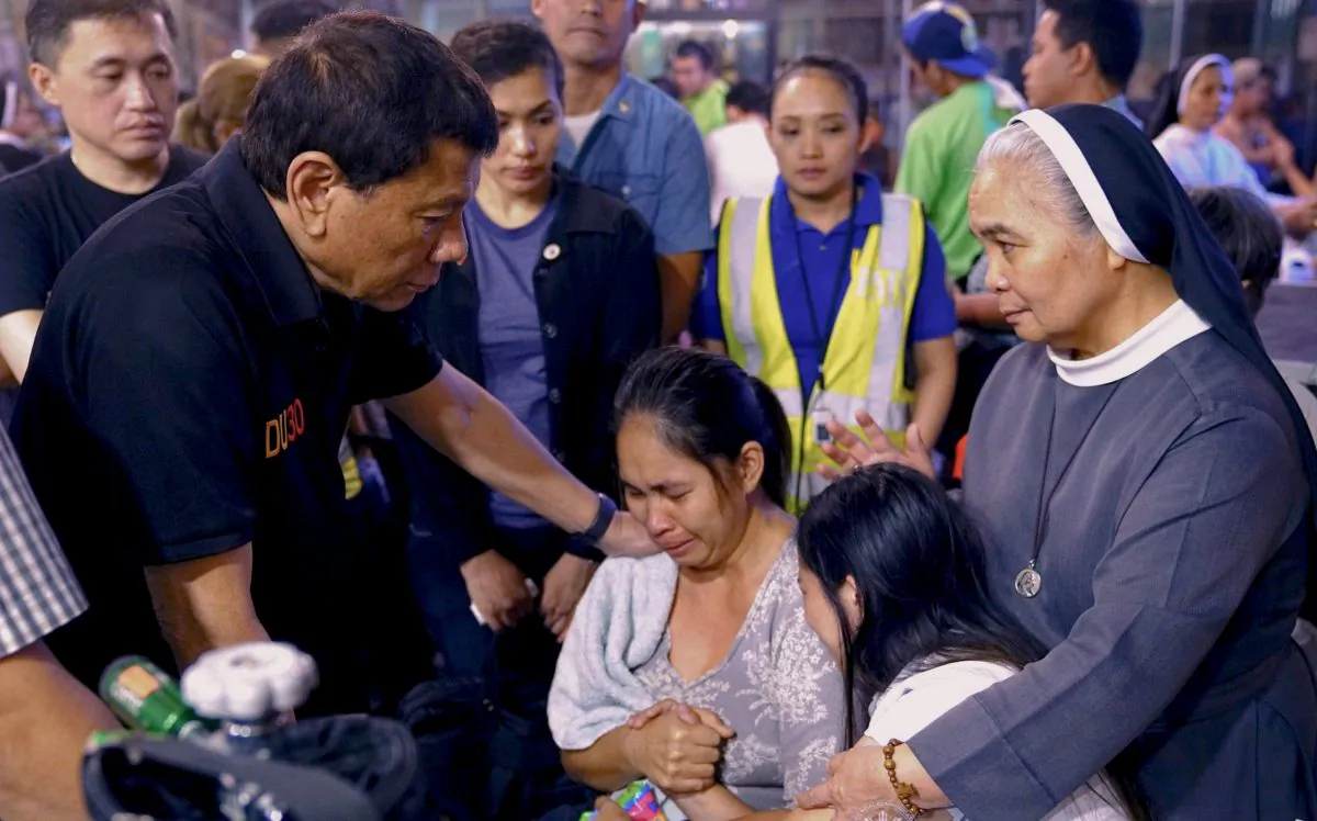President Rodrigo Duterte comforts family members of fire victims in Davao city in Philippines on Dec. 24, 2017. (Reuters/Presidential Palace)