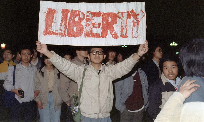 A student displays a banner among the crowd of some 200,000 who poured into Tiananmen Square on April 22, 1989. The April-June 1989 movement was crushed by Chinese troops who killed at least 10,000 people, a secret British diplomatic cable has alleged. (Catherine Henriette/AFP/Getty Images)