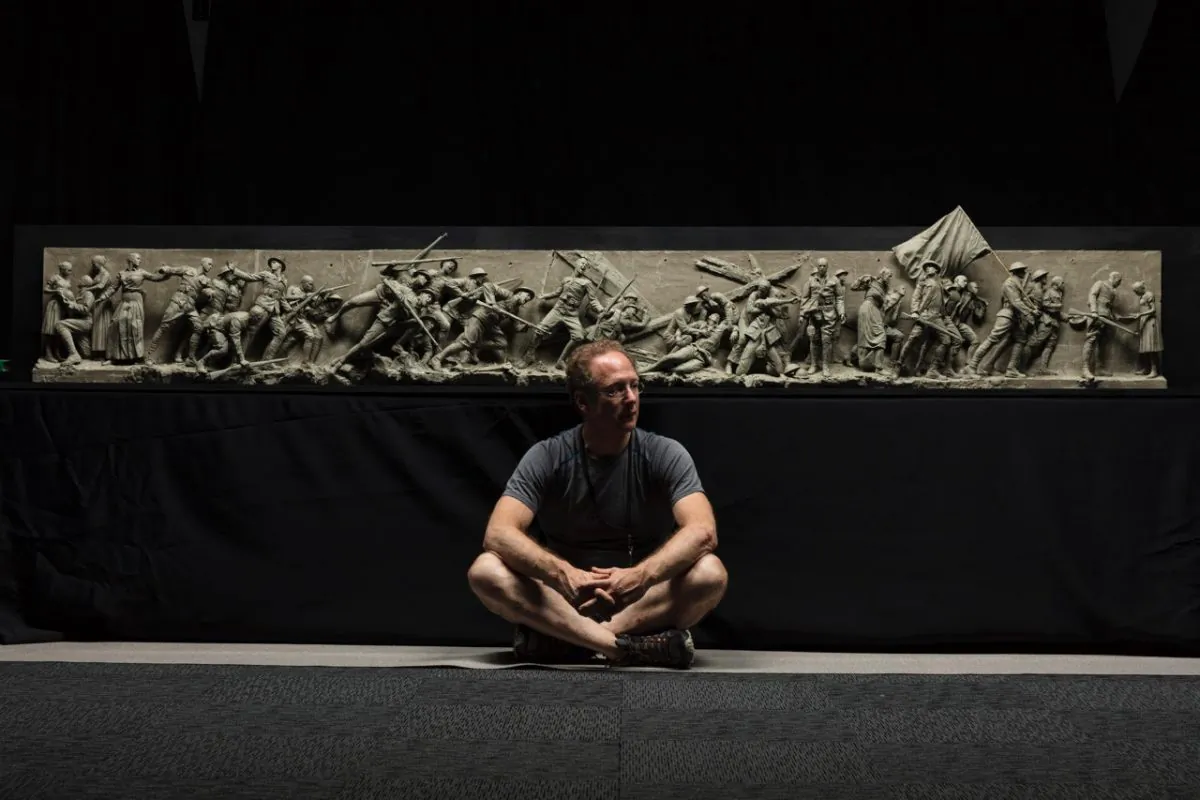 Sculptor Sabin Howard sits with the maquette he created for "A Soldier's Journey," the sculptural component of the National World War I Memorial, at Weta Workshop in Wellington, New Zealand, in November 2017. (Courtesy of Sabin Howard)