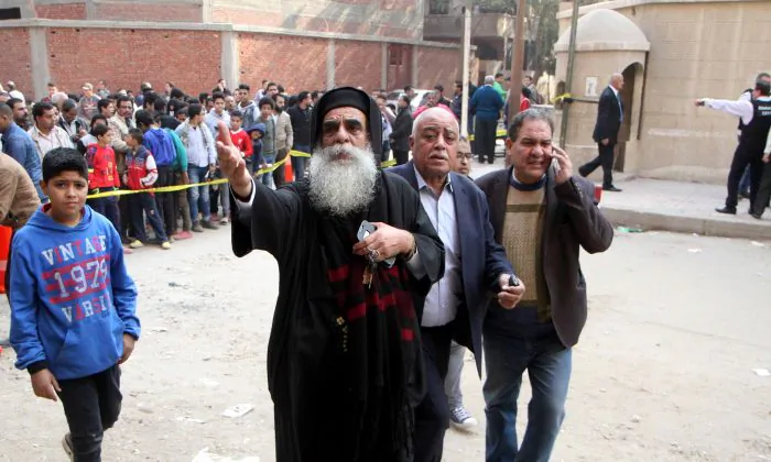 Egyptian onlookers are seen gathered at a cordoned off area following a gun attack outside a church south of the capital Cairo, on Dec. 29, 2017. A gunman opened fire on a church, killing at least nine people before policemen shot him dead, state media and officials said.
 (STRINGER/AFP/Getty Images)