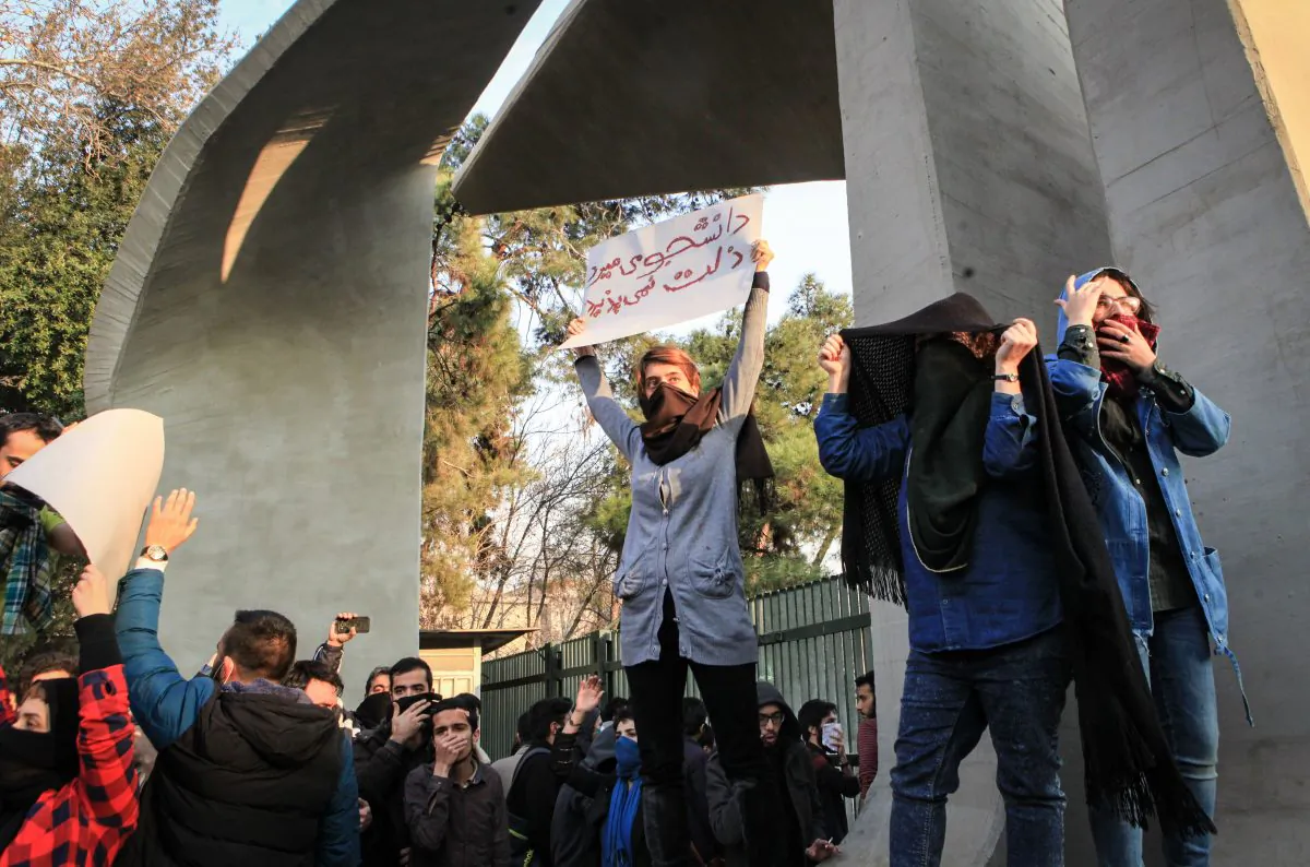 Students protest the Iranian regime at the University of Tehran on Dec. 30, 2017. One of the students is holding a sign in Persian, which translates to, "Students would rather die than accept oppression." (STR/AFP/Getty Images)
