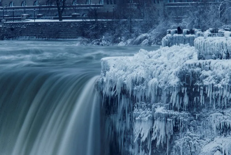 A lone visitor takes a picture near the brink of the ice covered Horseshoe Falls in Niagara Falls, Canada. (REUTERS/Aaron Lynett)