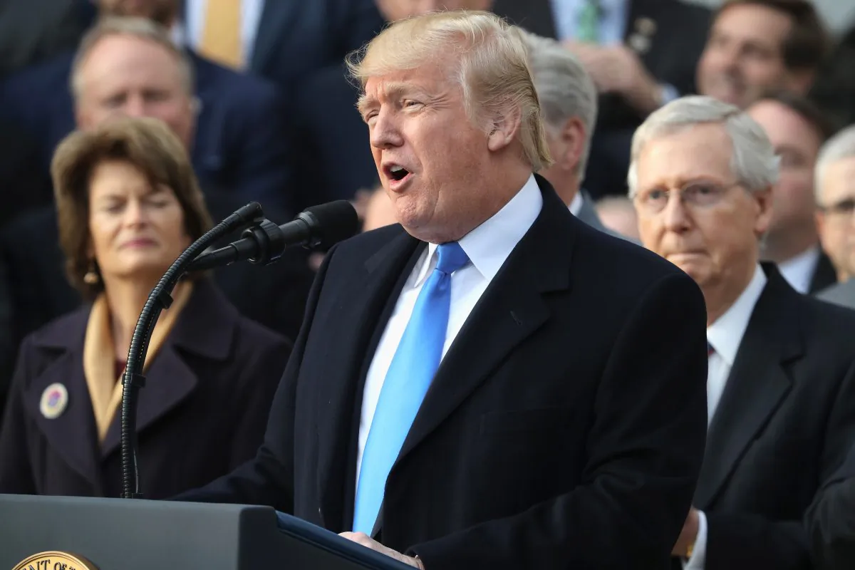 U.S. President Donald Trump, flanked by Republican lawmakers, celebrates Congress passing the Tax Cuts and Jobs Act on the South Lawn of the White House on Dec. 20, 2017 in Washington, D.C. The biggest threat to the Canadian economy comes from companies already operating in both countries that may move more operations to the United States. (Chip Somodevilla/Getty Images)
