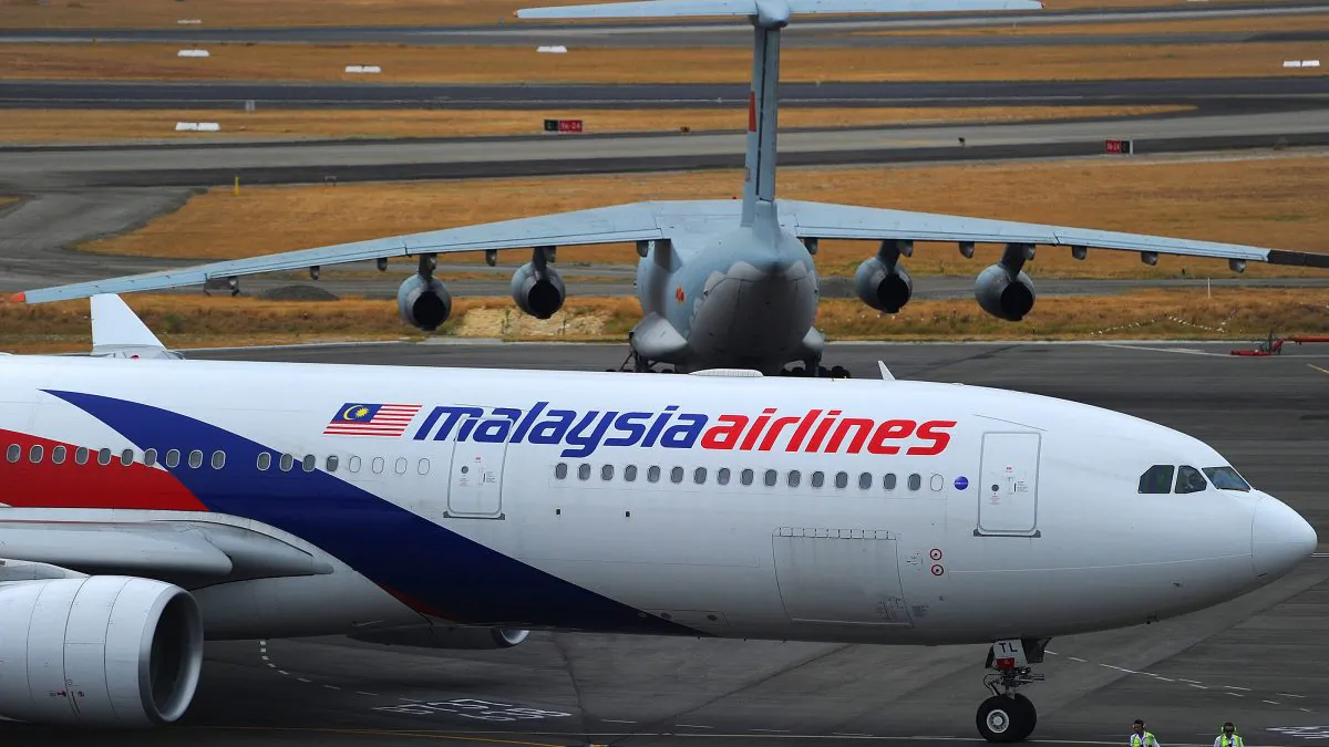 A Malaysia Airlines plane (below) prepares to go onto the runway and pass by a stationary Chinese Ilyushin 76 aircraft (top) at Perth International Airport on March 25, 2014. (Greg Wood/AFP/Getty Images)