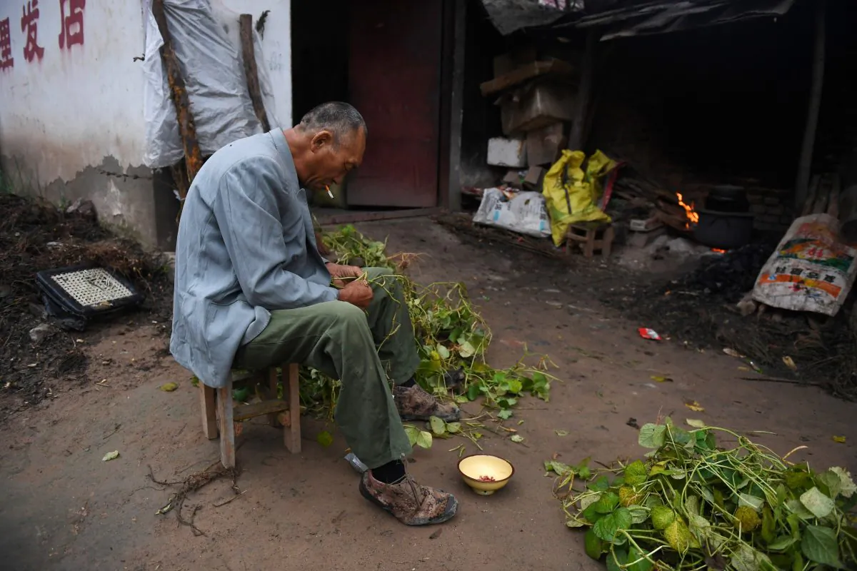 A man prepares beans outside his house in a village near the Yellow River in Lankao County, Henan Province, on Sept. 28, 2017. (Greg Baker/AFP/Getty Images)