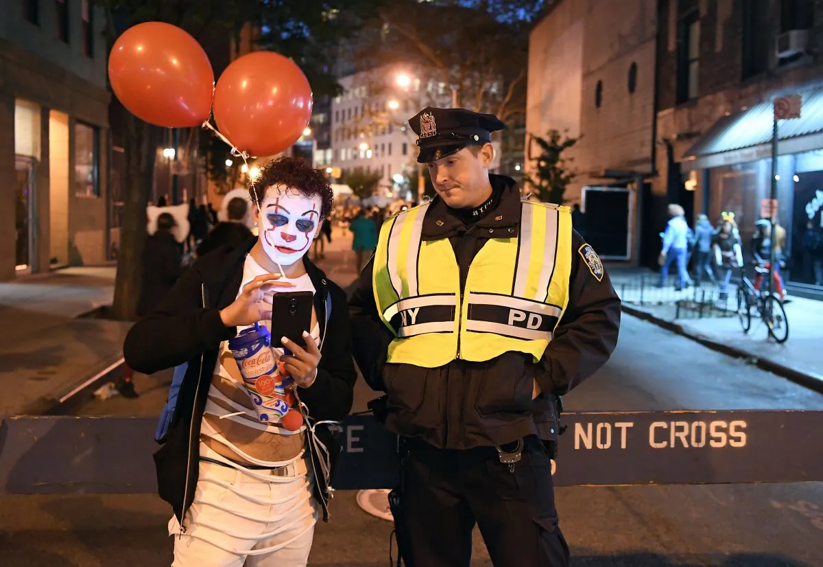 A man dressed in a clown costume talks to an NYPD officer during the 44rd Annual Halloween Parade in New York on Oct. 31, 2017. (ANGELA WEISS/AFP/Getty Images)