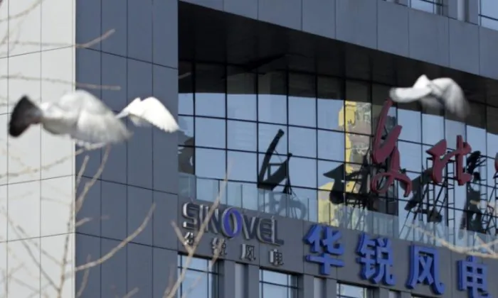 Pigeons fly past the company logo of Sinovel Wind Co., Ltd. outside its head office in Beijing, on Jan. 6, 2011. (Soo Hoo Zheyang/REUTERS)