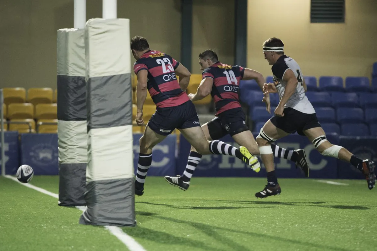 Natixis HKFC players Marno Meyer (23) and Charles Higson Smith race to score ahead of Herbert Smith Freehills HKCC  player Lawrence Babe in the HKRU Premiership at HKFC on Saturday Jan 20. (Bill Cox/Epoch Times)