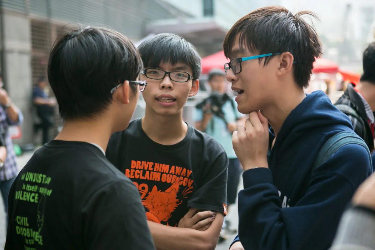 Joshua Wong (C), one of three Nobel Peace Prize nominees who led the 2014 pro-democracy protests in Hong Kong, chats with student leaders during the protests, on Nov. 18, 2014. (Benjamin Chasteen/The Epoch Times)
