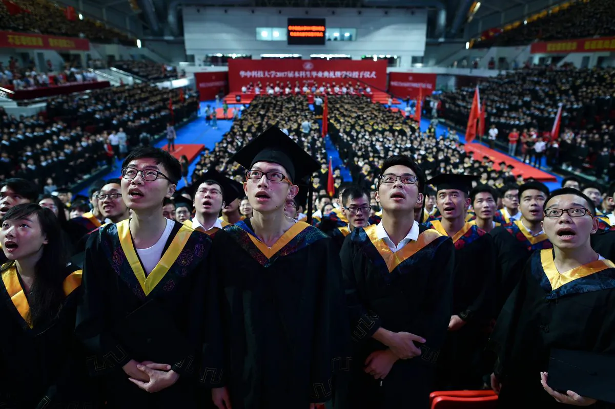 Students from the Huazhong University of Science and Technology singing during their graduation ceremony in a sports stadium in Wuhan City, in China's central Hubei province, on June 20, 2017. (STR/AFP/Getty Images)