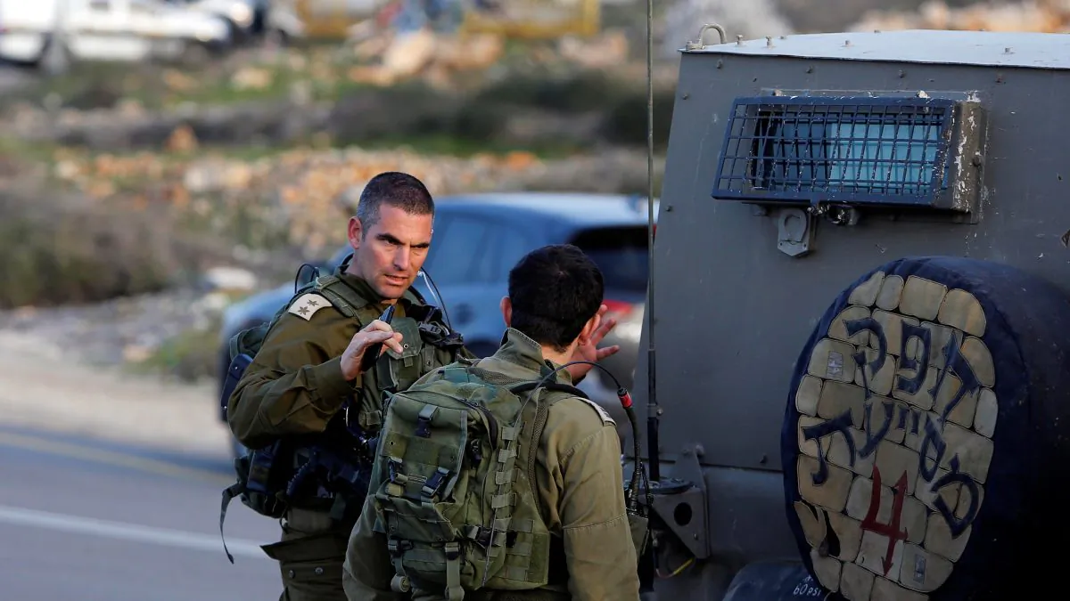 An Israeli soldier gestures as he stands near the scene of a stabbing attack north of Hebron, in the occupied West Bank, Feb. 7, 2018. (Reuters/Mussa Qawasma)