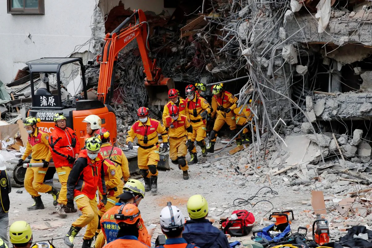 Rescuers run out of a hotel during an aftershock after an earthquake hit Hualien, Taiwan Feb. 7, 2018. (Reuters/Tyrone Siu)