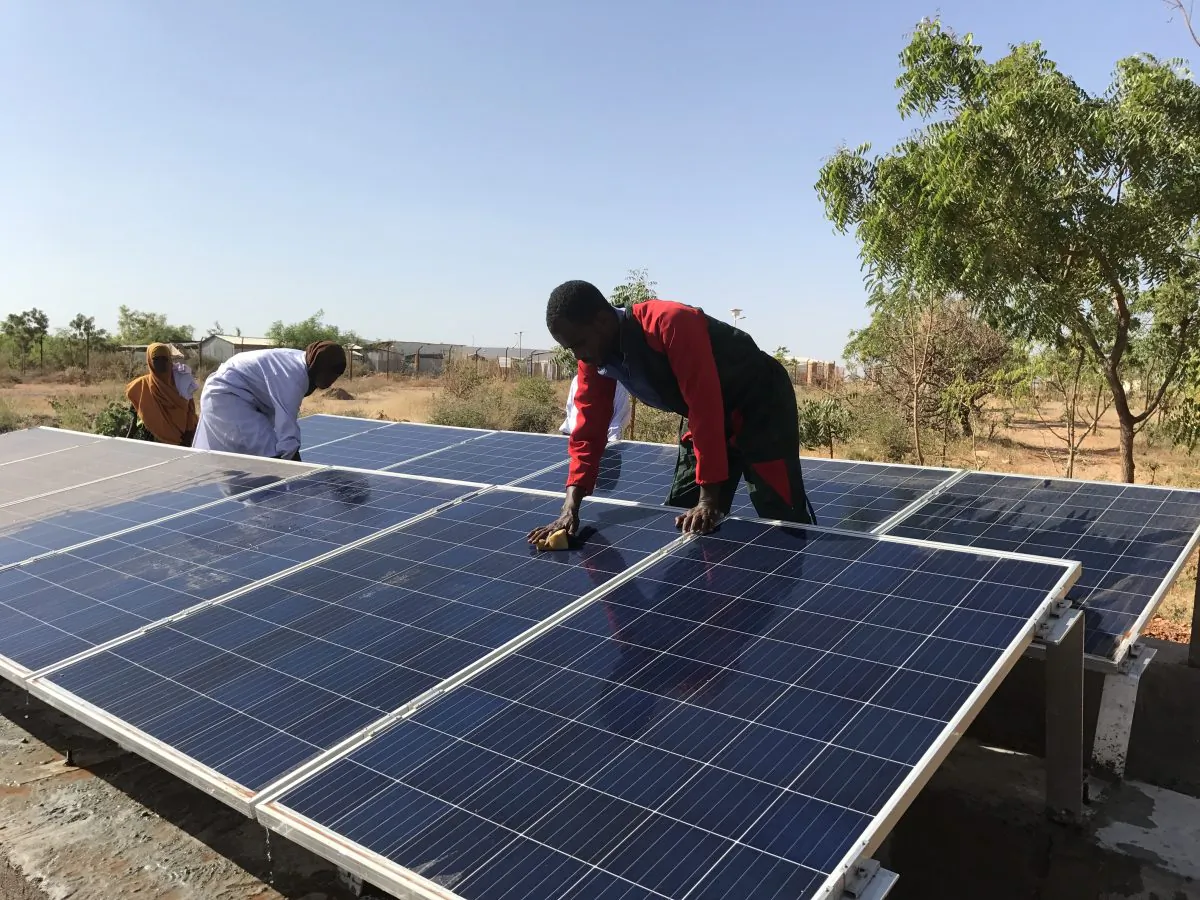 Adullahi Mohomed Adow carefully cleans dusty solar panels as routine maintenance in the hot and dusty climate of the Somali Region of Ethiopia. (Lisa Sim/Epoch Times)