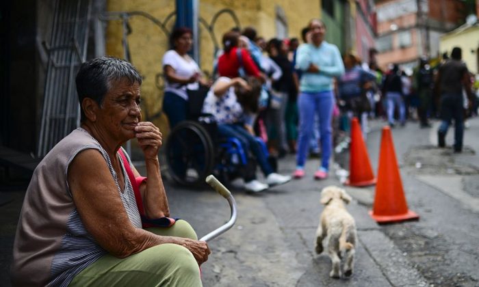 An elderly woman lines up to buy basic food and household items outside a supermarket in the poor neighborhood of Lidice, in Caracas, Venezuela on May 27, 2016. (RONALDO SCHEMIDT/AFP/Getty Images)