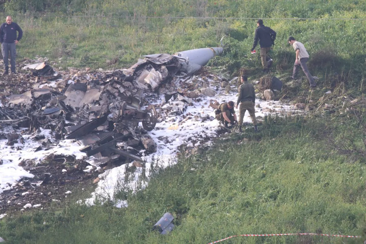 Israeli security forces walk next to the remains of an F-16 Israeli war plane near the Israeli village of Harduf, Israel Feb. 10, 2018. (Reuters/Herzie Shapira)