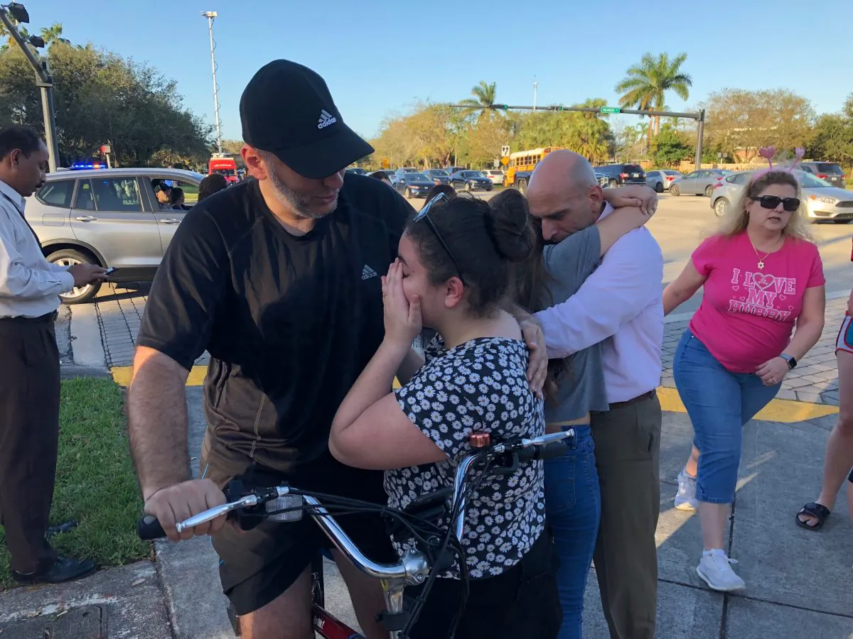 People react at Marjory Stoneman Douglas High School in Parkland, Florida, a city about 50 miles (80 kilometers) north of Miami following a school shooting on Feb. 14, 2018. (MICHELE EVE SANDBERG/AFP/Getty Images)