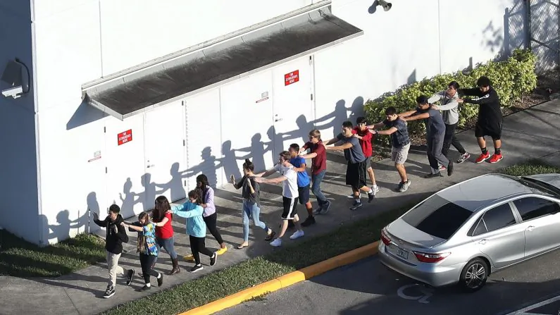 People are brought out of the Marjory Stoneman Douglas High School after a shooting at the school that left 17 people dead in Parkland, Florida, on Feb. 14, 2018. (Joe Raedle/Getty Images)
