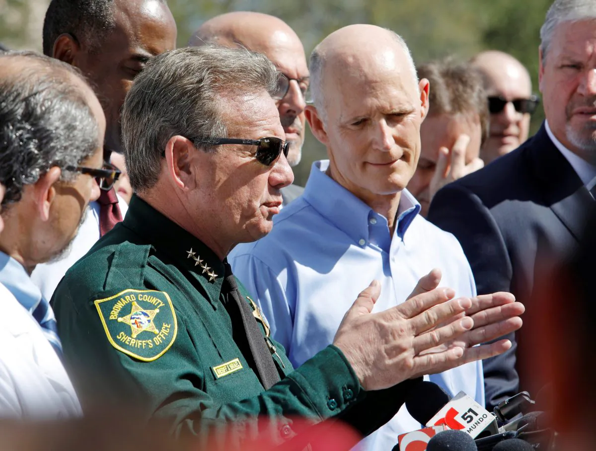 Broward County Sheriff Scott Israel speaks to the media while Florida Gov. Rick Scott listens outside Marjory Stoneman Douglas High School one day after a shooting at the school left 17 dead, in Parkland, Fla., Feb. 15, 2018. (Jonathan Drake/Reuters)