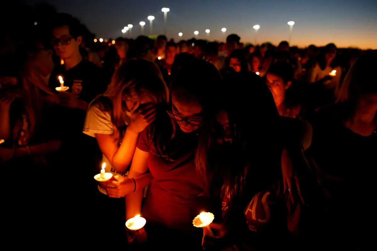 People attend a candlelight vigil for victims of yesterday's shooting at nearby Marjory Stoneman Douglas High School, in Parkland, Florida on Feb. 15, 2018. (Reuters/Carlos Garcia Rawlins)