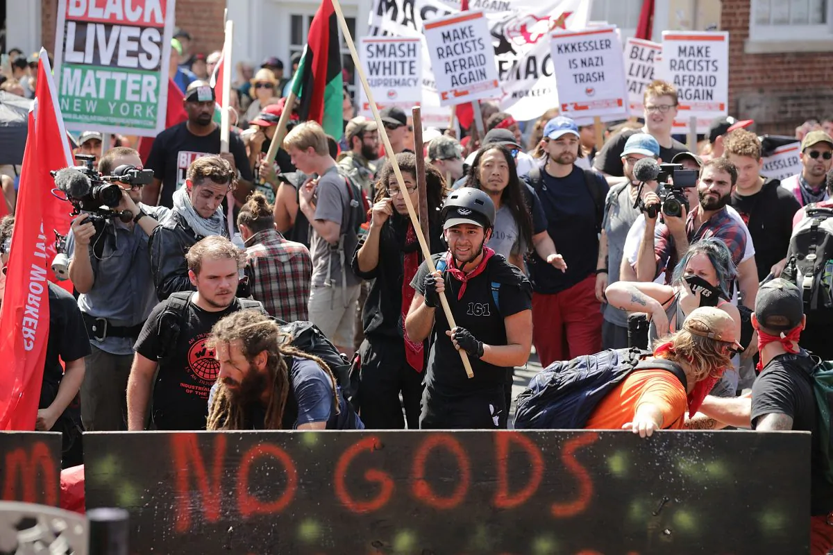 Protesters, including members of the communist extremist group Antifa, hold signs during an Aug. 12, 2017, protest in Charlottesville, Va. According to a new book, social conflicts are being used by special interest groups and governments to shape narratives and alter public perception. (Chip Somodevilla/Getty Images)