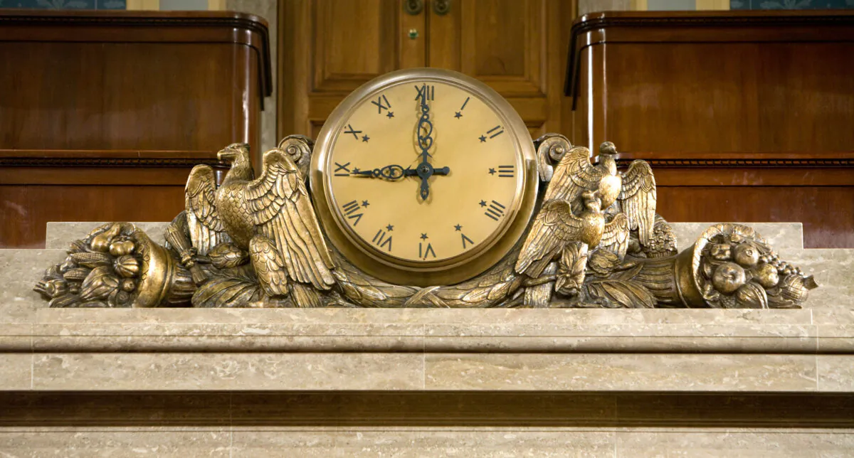 A clock over the Speaker's rostrum in the U.S. House of Representatives chamber is seen on Dec. 8, 2008 in Washington, DC. (Photo by Brendan Hoffman/Getty Images)