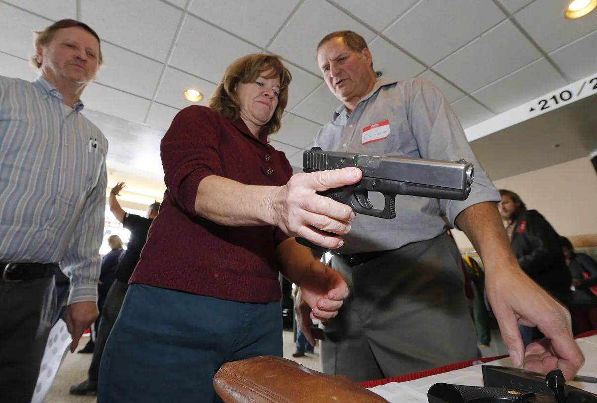 A Utah teacher is shown how to handle a handgun by instructor Clint Simon (R), at a concealed-weapons training class to 200 Utah teachers in West Valley City, Utah on Dec. 27, 2012. (Photo by George Frey/Getty Images)