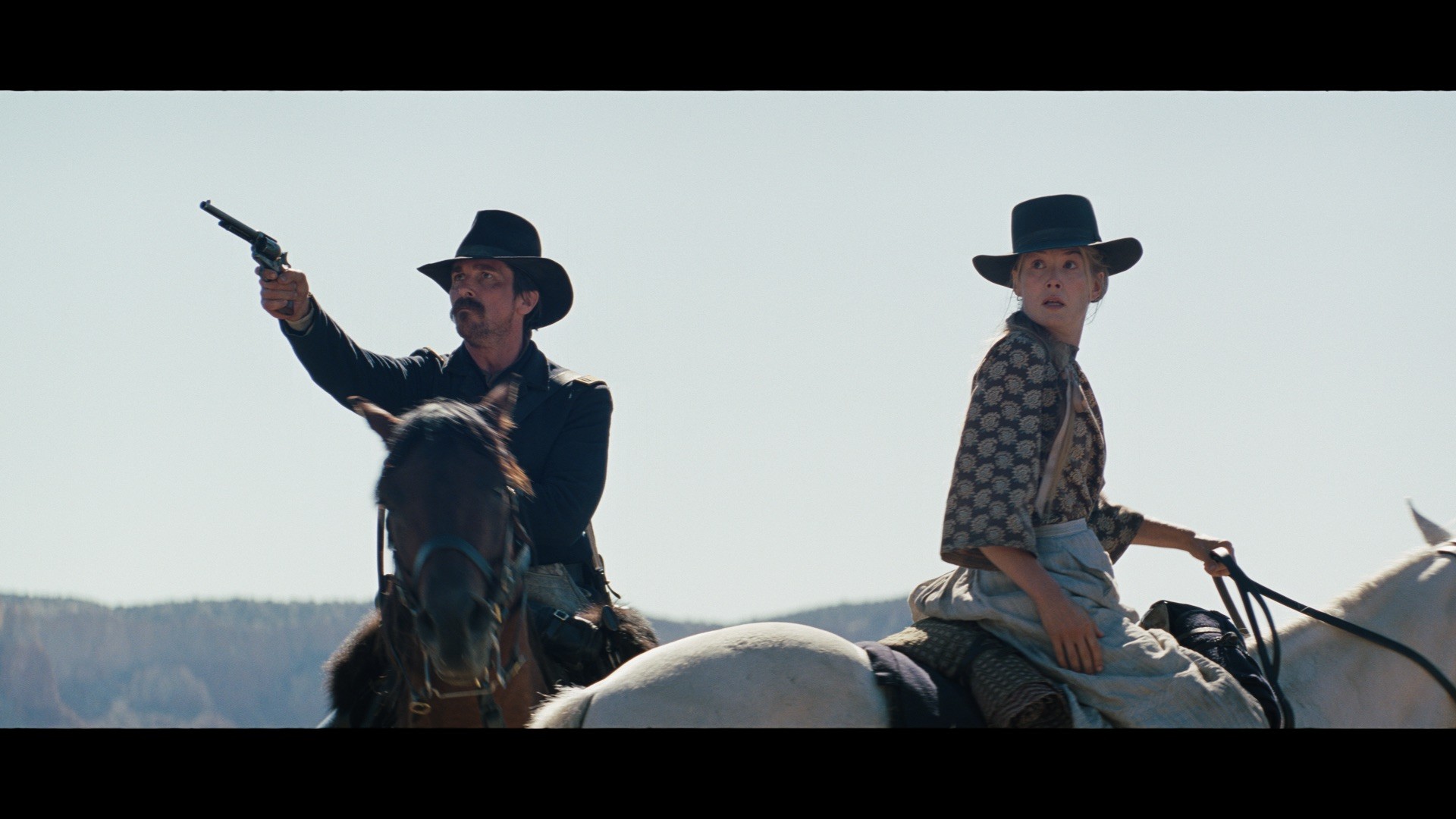 man and woman on horses in hostiles