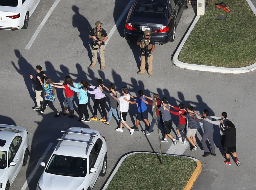 People are brought out of the Marjory Stoneman Douglas High School after a shooting at the school left 17 people dead on February 14, 2018 in Parkland, Florida. (Joe Raedle/Getty Images)